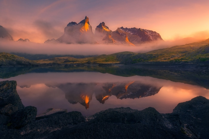 Torres del Paine mountains reflected in a lake at sunrise