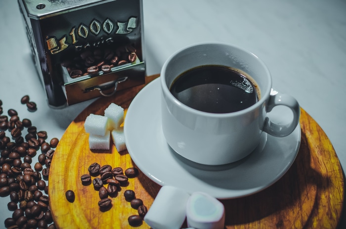 Coffee cup with beans, sugar cubes, and marshmallows