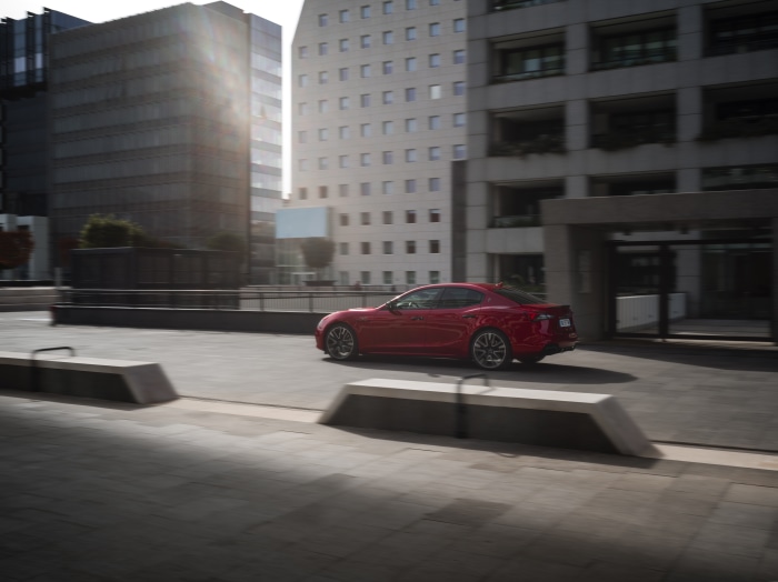 Red Maserati Ghibli driving in urban environment