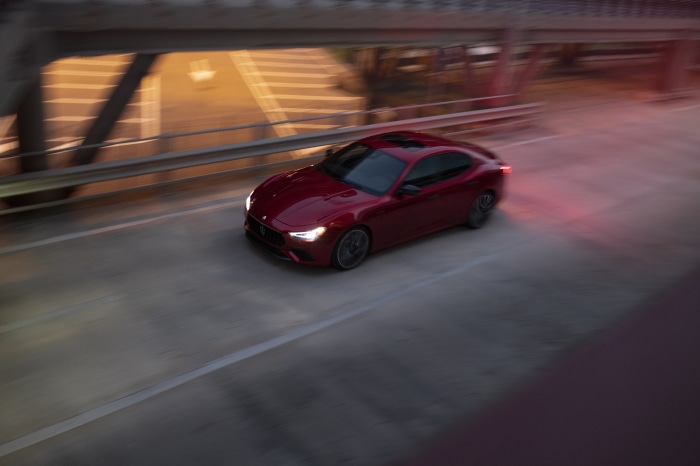 Red Maserati Ghibli driving on a bridge