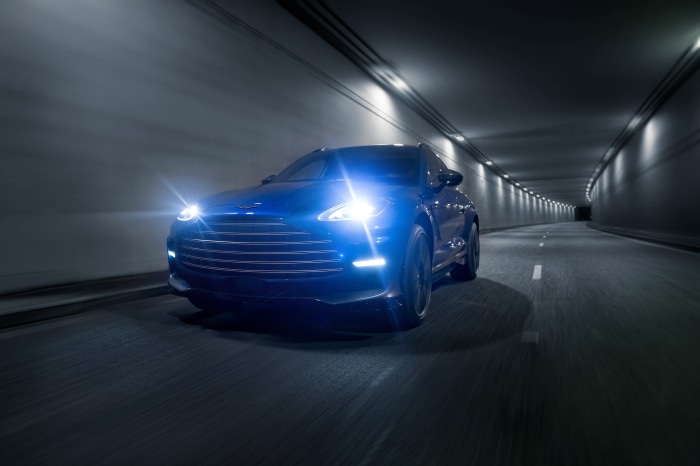 Blue Aston Martin DBX707 driving through a tunnel
