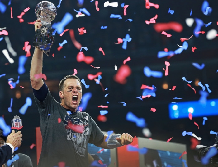 Tom Brady holding Super Bowl trophy with confetti