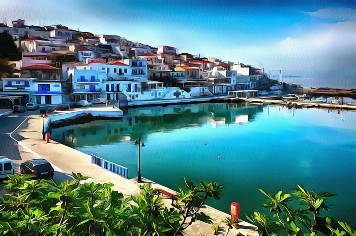 Coastal village with white buildings and blue shutters on a hillside overlooking a turquoise bay.
