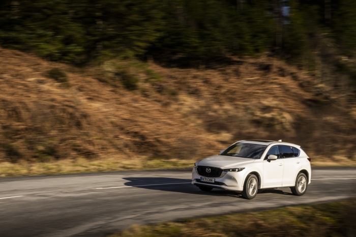 White Mazda CX-5 SUV driving on a road