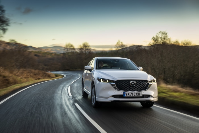 White Mazda CX-5 driving on a winding road