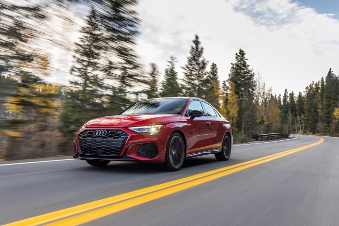 Red Audi A3 Sedan driving on a mountain road