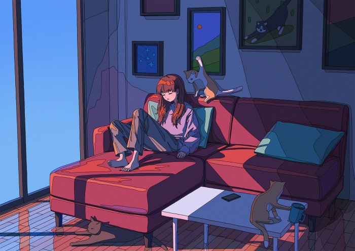 Girl relaxing on a couch with cats