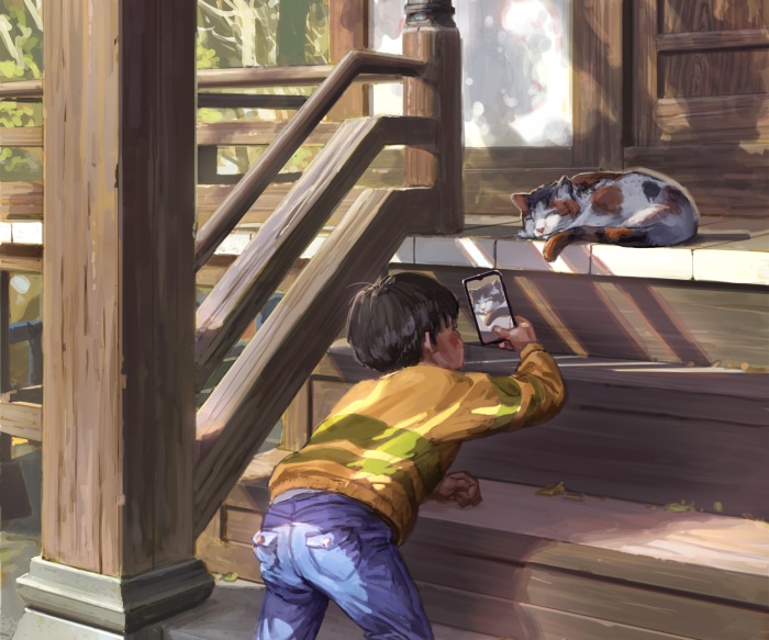Boy taking a photo of a sleeping cat