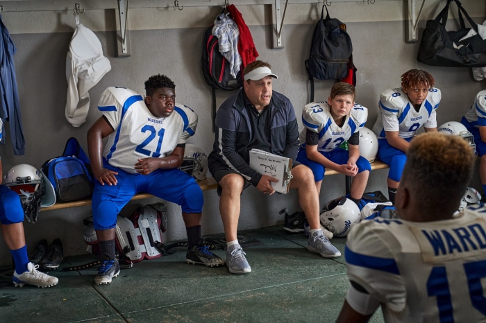 Kevin James and football players in locker room