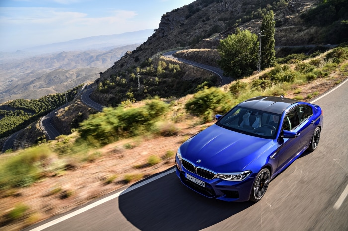 Blue BMW M5 on a winding mountain road