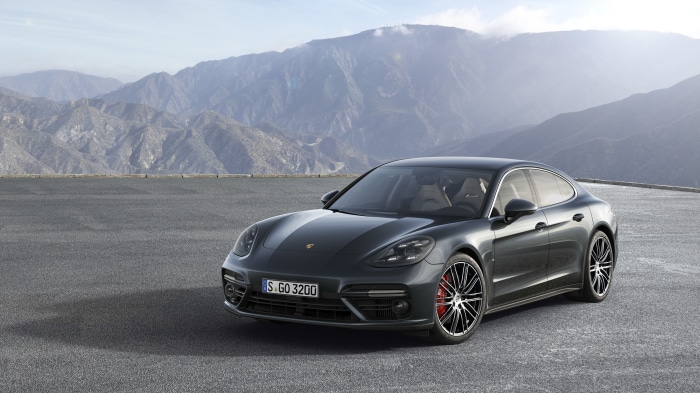 Porsche Panamera car on asphalt road with mountains