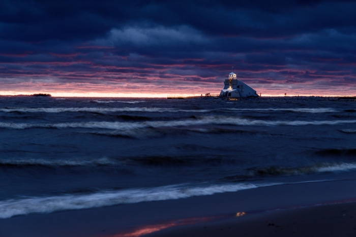 Lighthouse on the water at sunset
