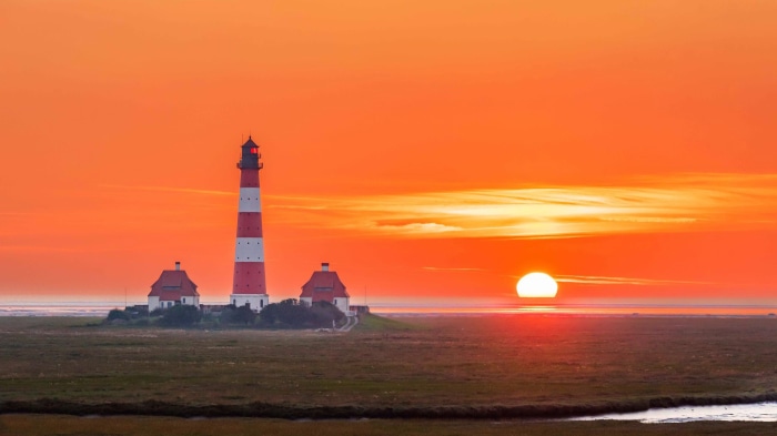 Lighthouse at sunset over the ocean