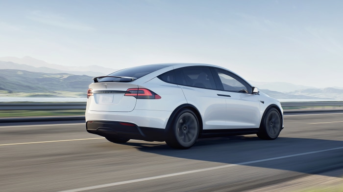 White Tesla Model X Plaid driving on a road