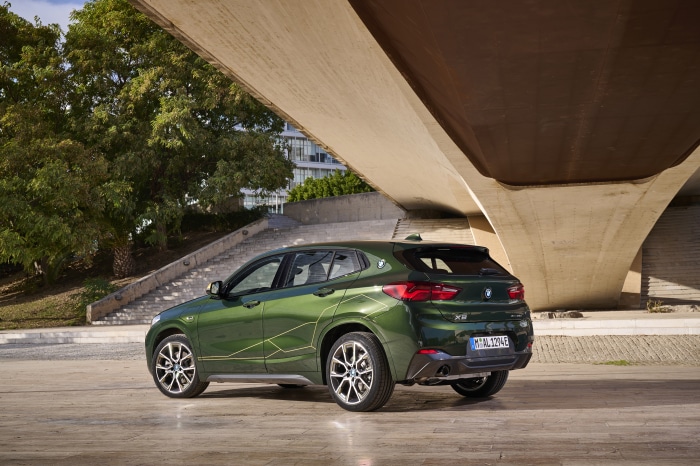 Green BMW X2 xDrive25e parked under a bridge