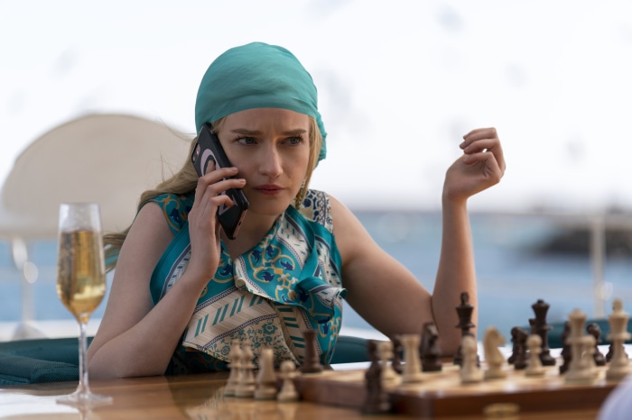 Julia Garner as Anna Delvey playing chess on a yacht