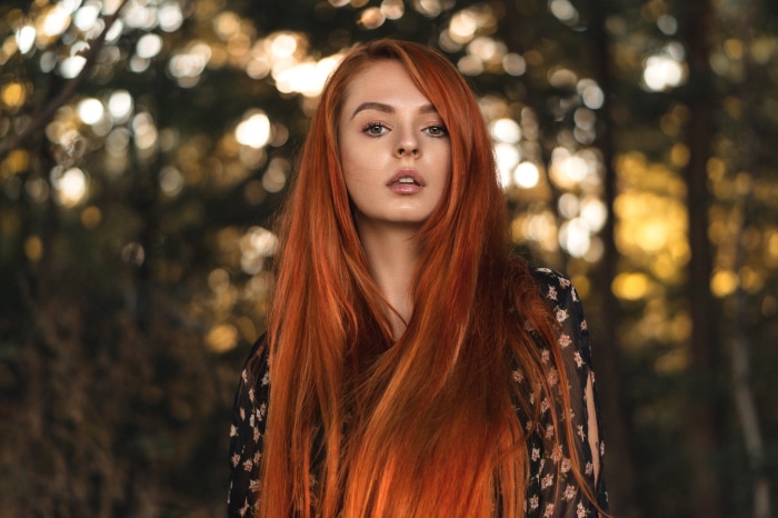 Redhead woman with long hair in forest