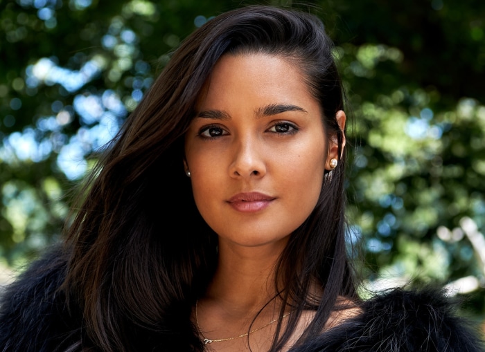 Woman with long black hair and pearl earrings