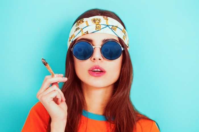 Woman wearing sunglasses and headband smoking