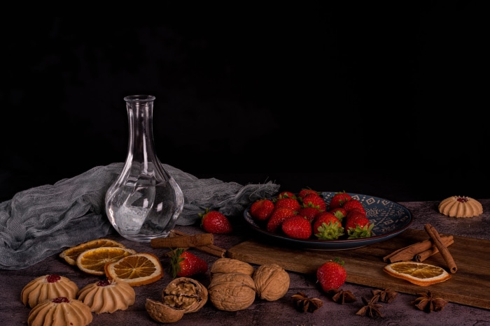 Still life with strawberries, cookies, and dried oranges