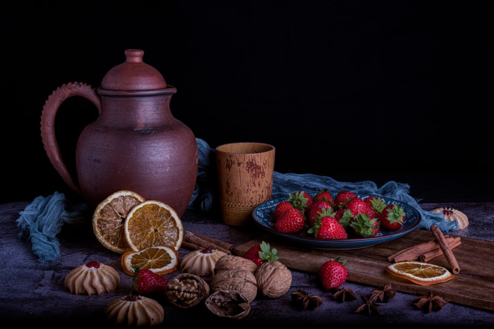 Still life with strawberries, nuts, and dried oranges