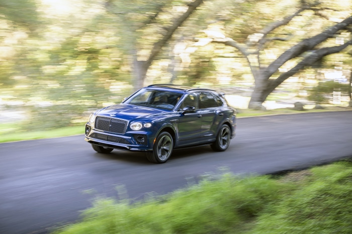 Blue Bentley Bentayga S driving on a road