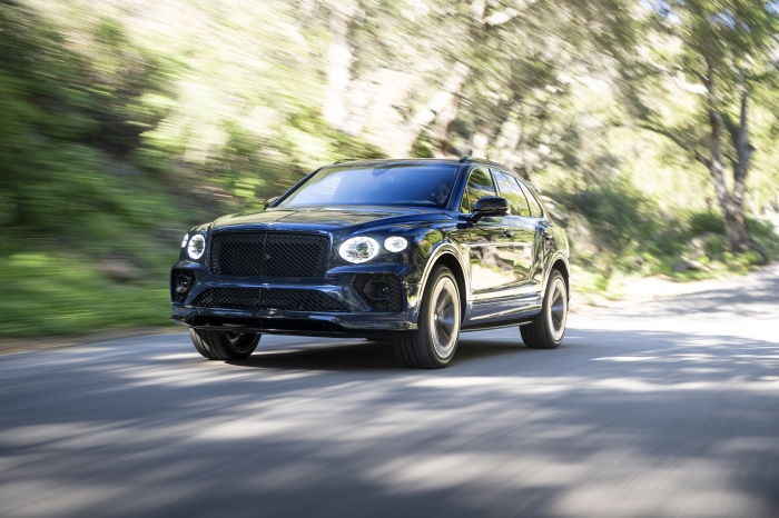 Bentley Bentayga S SUV driving on a tree-lined road