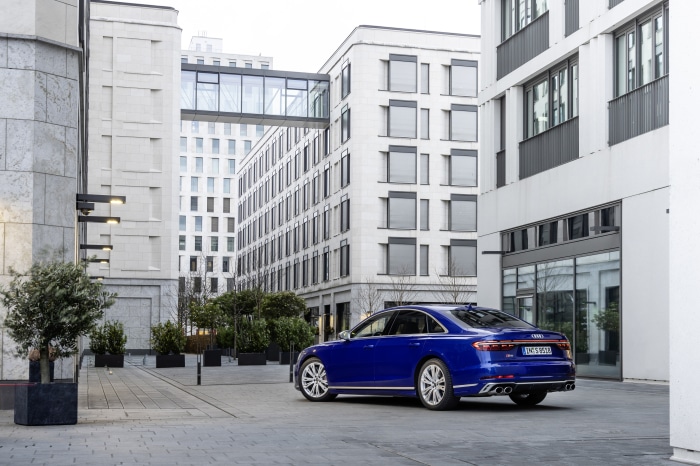Blue Audi S8 4K parked in front of modern buildings