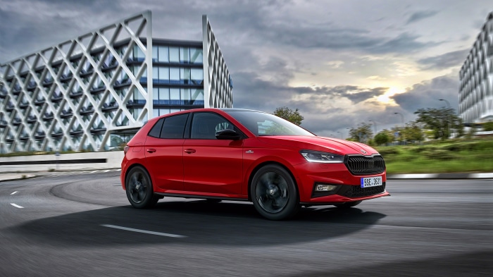 Red Škoda Fabia driving on a road
