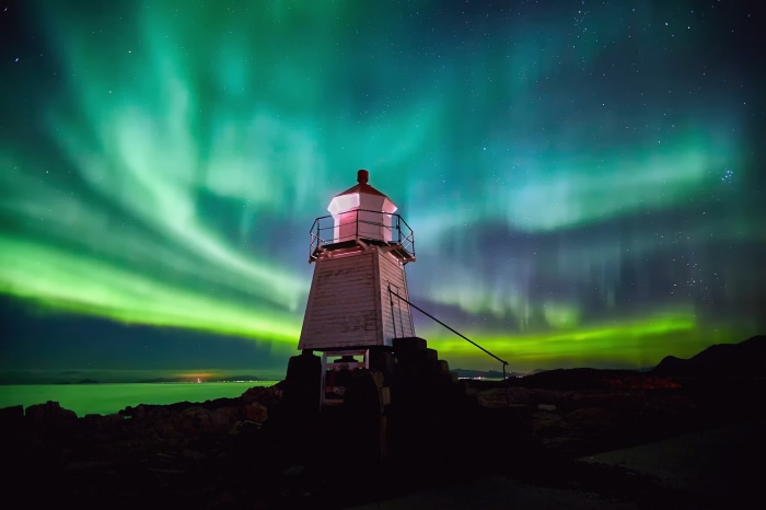 Lighthouse under Aurora Borealis at night