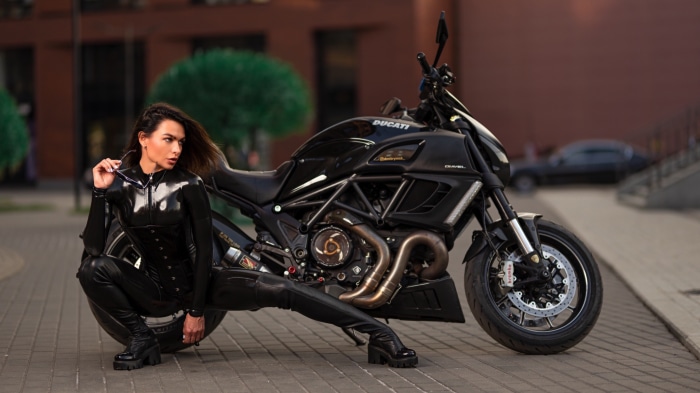 Woman in Latex Outfit Poses with Ducati Motorcycle