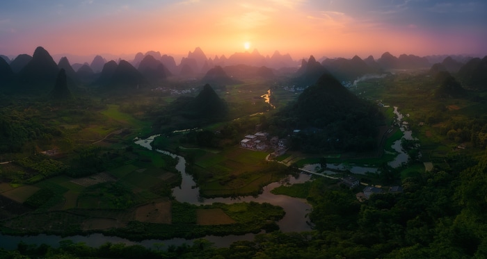 Sunrise over karst mountains and river in China