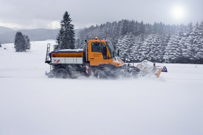 Mercedes-Benz Unimog snow plow truck spreading salt