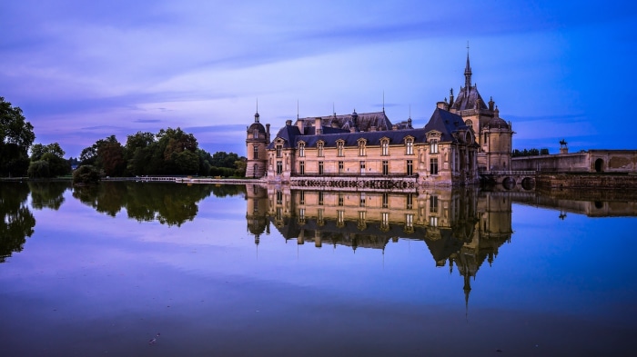 Château de Chantilly reflection in water at dusk