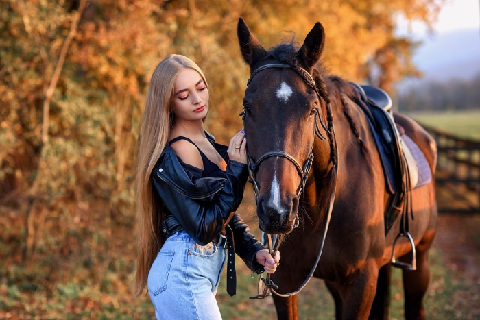 Woman in leather jacket with horse