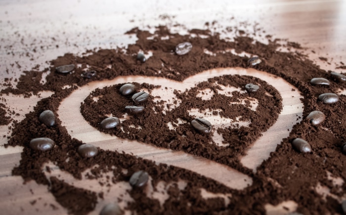 Heart shape made of coffee grounds and beans