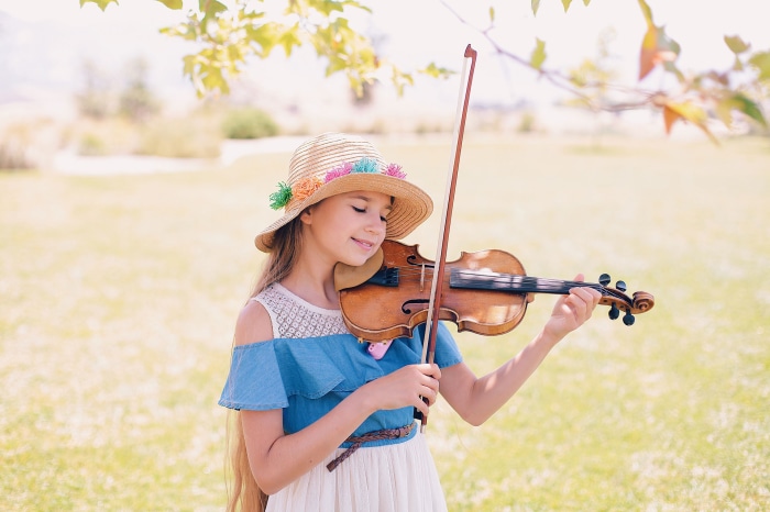 Girl playing violin outdoors