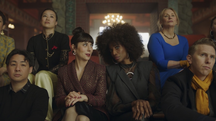 Zainab Johnson and friends sitting in an audience