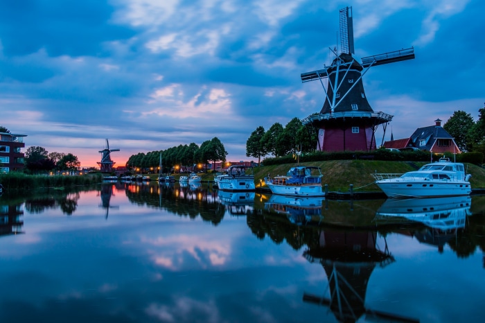 Windmills and boats on a canal in the Netherlands at dusk