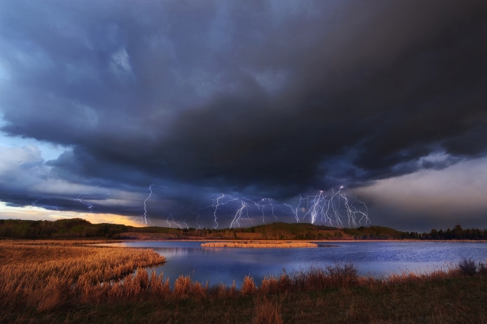 Lightning strikes over a lake during a storm