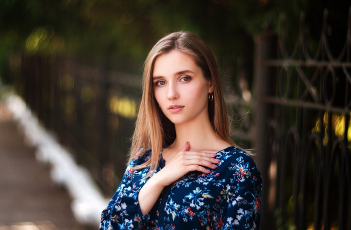 Woman in floral dress with hand on chest