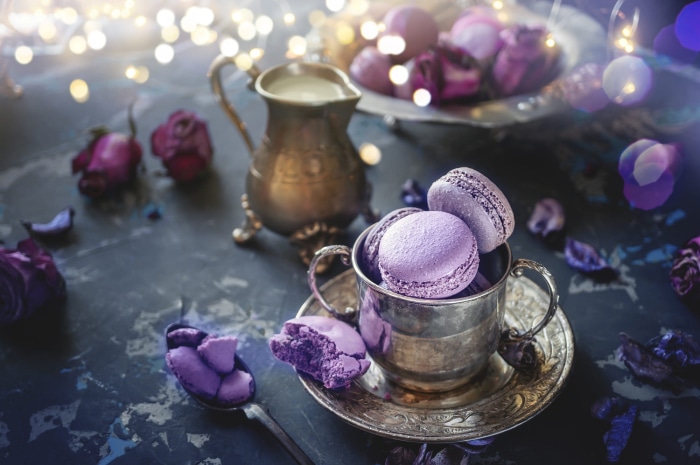Purple macarons in a silver cup with dried roses