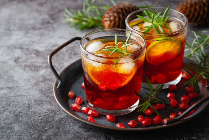 Pomegranate and orange cocktails with rosemary and ice