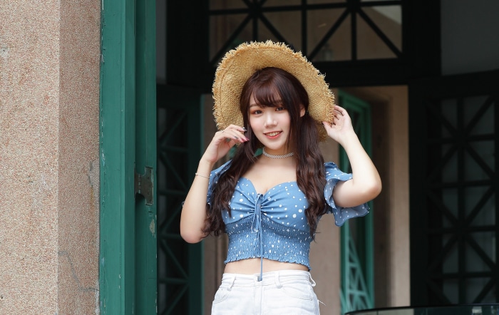 Young Asian woman in straw hat and blue polka dot top