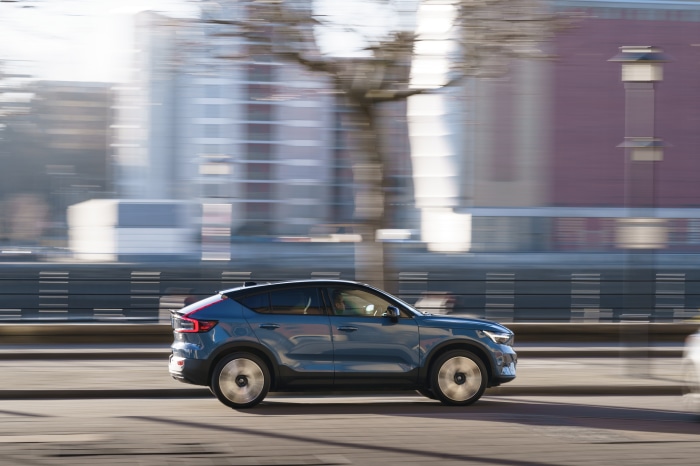 Blue Volvo C40 SUV driving on a city street