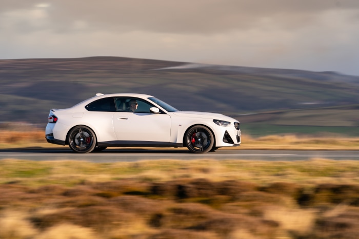 White BMW 220i Coupé M Sport driving on a road