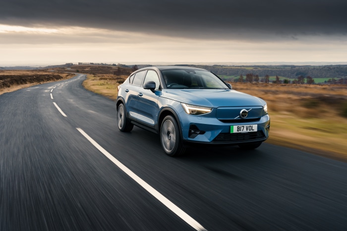 Blue Volvo C40 SUV driving on a winding road