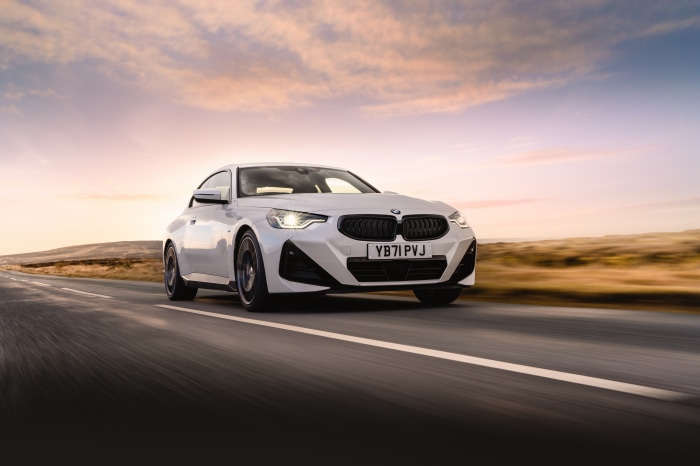 White BMW 220i Coupé M Sport driving on road
