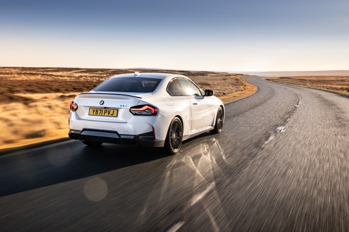 White BMW 220i Coupé M Sport driving on a road