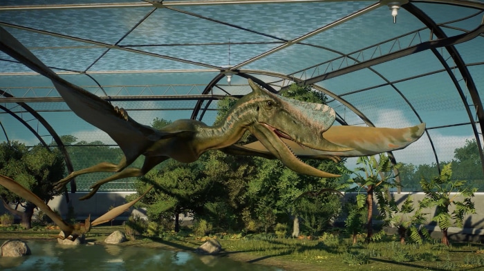 Pterosaurs flying in a greenhouse enclosure in Jurassic World Evolution 2